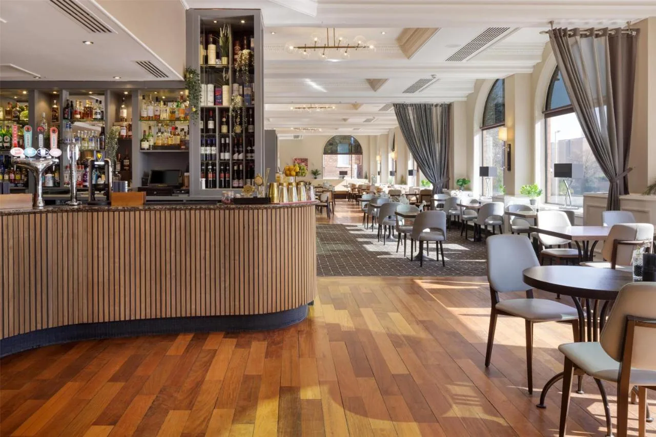 a restaurant with a bar and tables and chairs at Hilton York in York